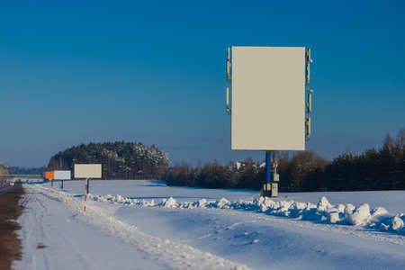 Background for design. Advertising billboard along the road in the city on a winter sunny dayの写真素材