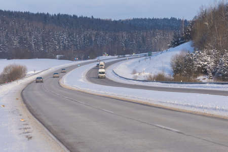Winter landscape, road and shoulder covered with snow.