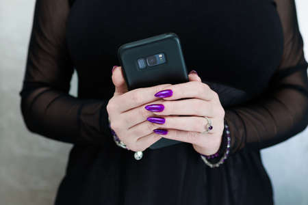 Woman's hands holding a smartphoneの写真素材