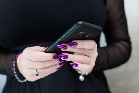 Woman's hands holding a smartphoneの写真素材