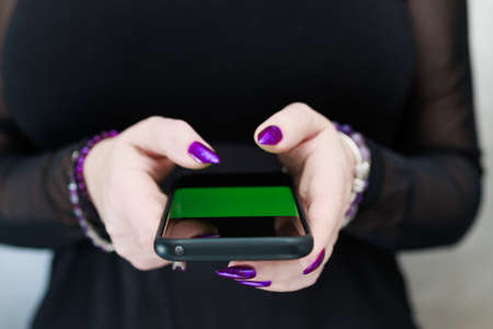 Woman's hands holding a smartphoneの写真素材