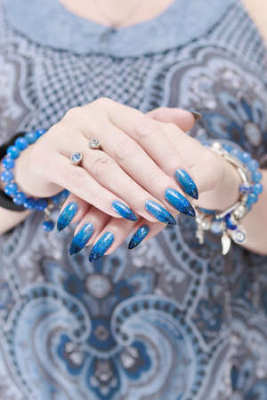 Female hands with long nails with bright blue nail polish