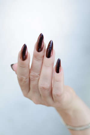 Female hands with long nails and black and red nail polishの写真素材