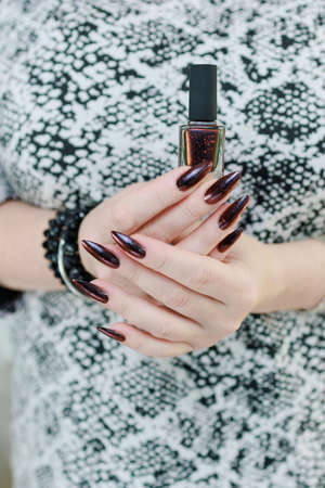 Female hands with long nails and black and red nail polish