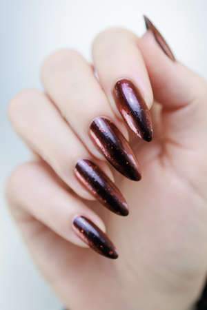 Female hands with long nails and black and red nail polishの写真素材