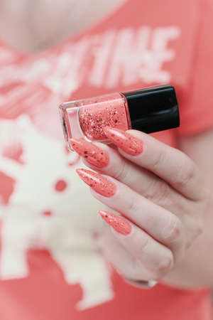 Female hands with long nails and neon pink nail polish