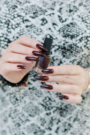 Female hands with long nails and black and red nail polishの写真素材