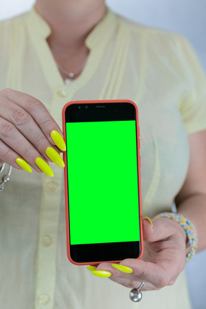 Woman's hands holding a large coral smartphoneの写真素材