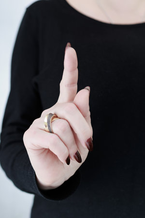 Woman hand with long nails and a bottle of dark red burgundy nail polishの写真素材