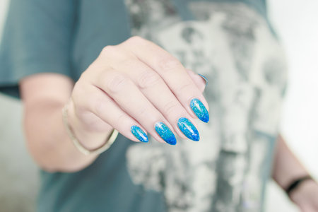 Woman's beautiful hand with long nails and light blue manicureの写真素材