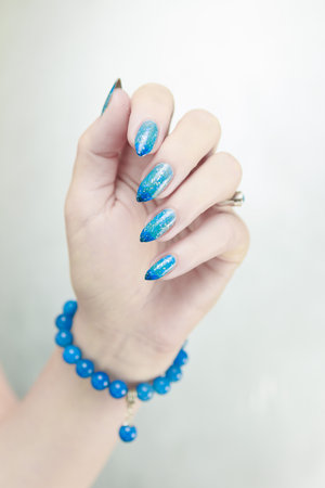 Woman's beautiful hand with long nails and light blue manicureの写真素材