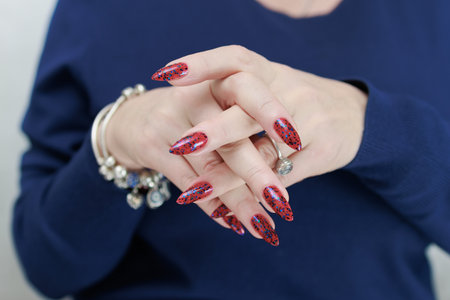 Female hand with long nails and a bright red manicureの写真素材