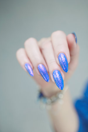 Female hand with long nails, pink and bright blue manicureの写真素材