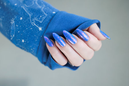 Female hand with long nails, pink and bright blue manicureの写真素材
