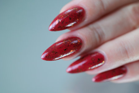 Female hand with long nails and a bright red manicure