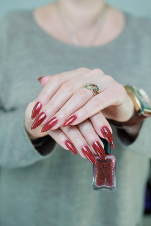 Female hand with long nails and a bright red manicureの写真素材