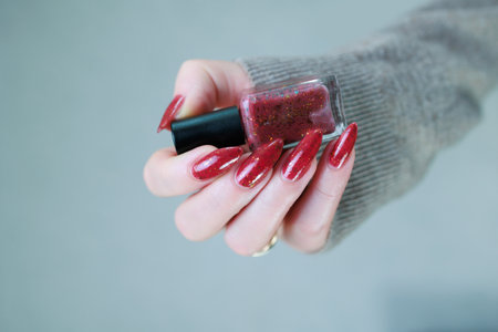 Female hand with long nails and a bright red manicureの写真素材