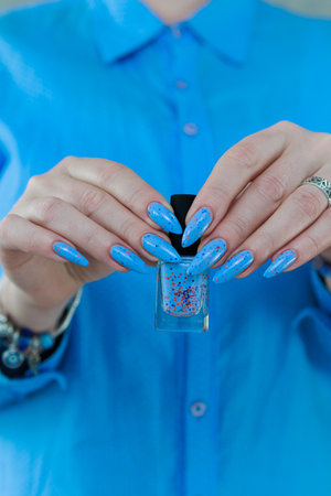 Female hand with long nails, pink and light blue manicureの写真素材