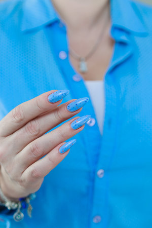 Female hand with long nails, pink and light blue manicureの写真素材