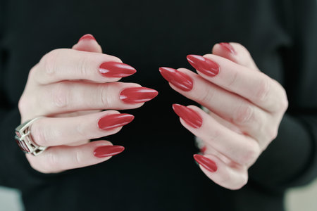 Female hand with long nails and a bright red manicureの写真素材