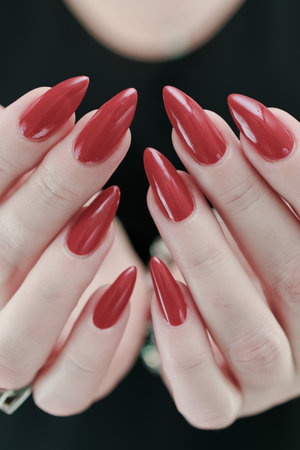 Female hand with long nails and a bright red manicureの写真素材