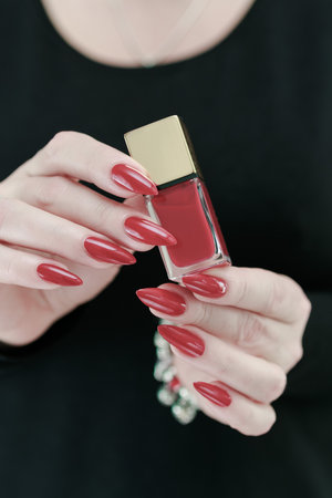 Female hand with long nails and a bright red manicureの写真素材