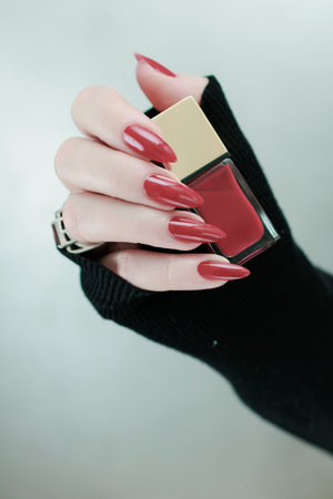 Female hand with long nails and a bright red manicureの写真素材
