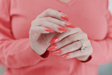 Woman hand with long nails and light orange coral neon manicureの写真素材