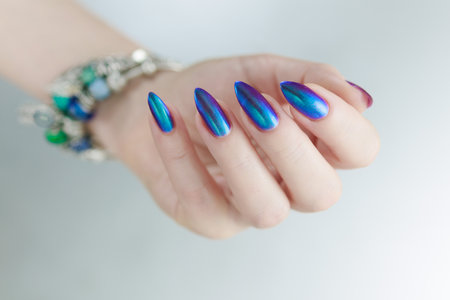 beautiful female hand with long nails, purple and blue manicureの写真素材