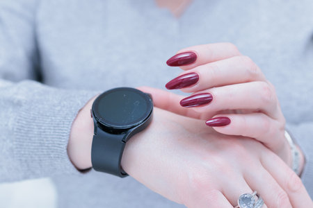 Woman's hands holding a smartphone and Digital Watchの写真素材