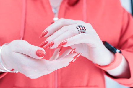 Female hand with long nails and a bright red manicureの写真素材