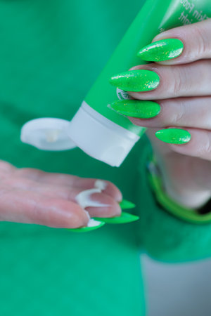 Women's hands hold a tube of hand creamの写真素材