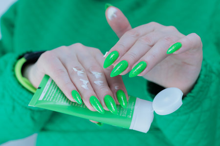 Women's hands hold a tube of hand cream