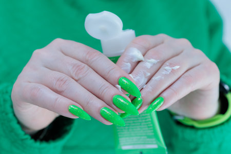 Women's hands hold a tube of hand creamの写真素材