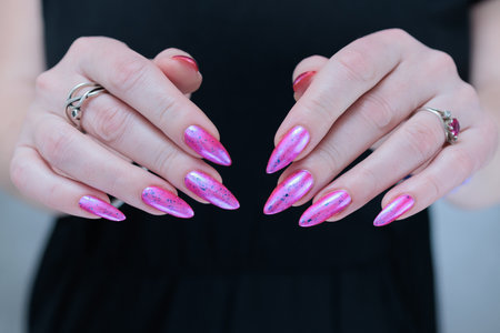 Woman hand with long nails manicure and light pink and blue nail polishの写真素材
