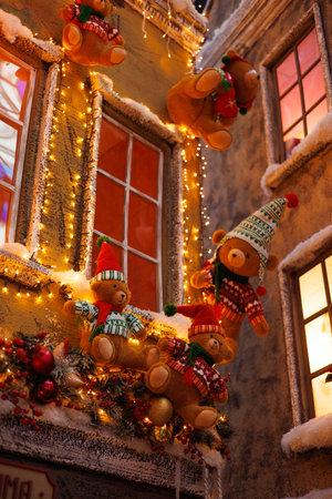 Background for design. New Year's decorations, toys and garlands on the windows in fabulous scenery. Houses for children in a public place.の写真素材