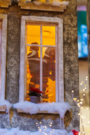 Background for design. New Year's decorations, toys and garlands on the windows in fabulous scenery. Houses for children in a public place.の写真素材