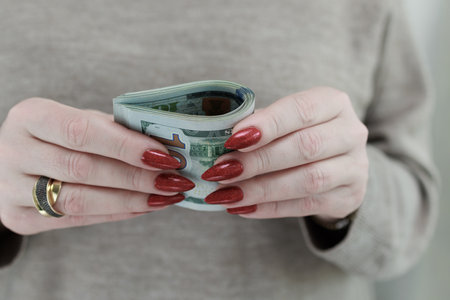 woman's hands holding American dollar paper billsの写真素材