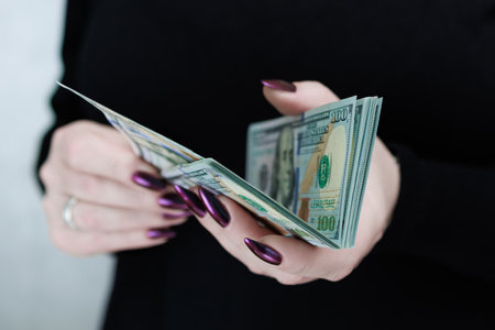 woman's hands holding American dollar paper billsの写真素材
