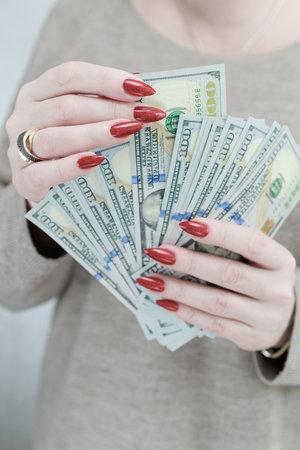 woman's hands holding American dollar paper bills