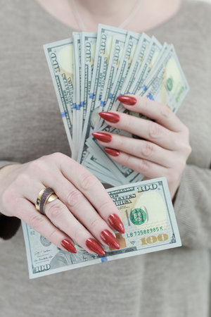 woman's hands holding American dollar paper bills