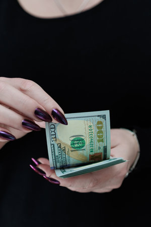 woman's hands holding American dollar paper billsの写真素材