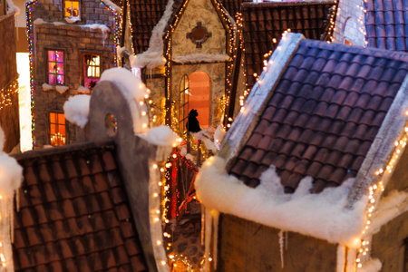 Background for design. New Year's decorations, toys and garlands on the windows in fabulous scenery. Houses for children in a public place.の写真素材
