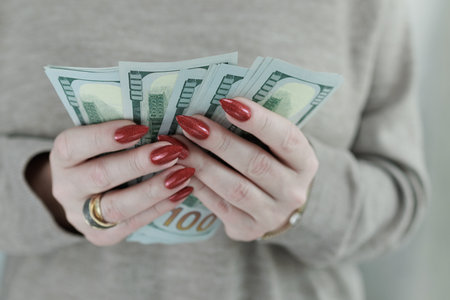 woman's hands holding American dollar paper billsの写真素材