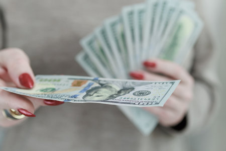 woman's hands holding American dollar paper billsの写真素材