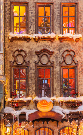 Background for design. New Year's decorations, toys and garlands on the windows in fabulous scenery. Houses for children in a public place.の写真素材