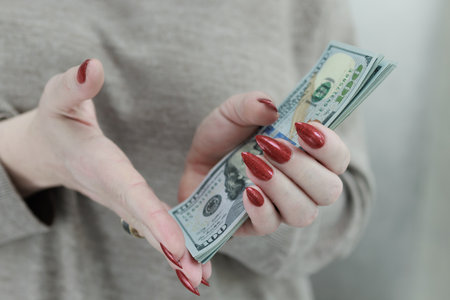woman's hands holding American dollar paper billsの写真素材