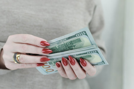 woman's hands holding American dollar paper billsの写真素材