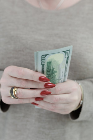 woman's hands holding American dollar paper billsの写真素材