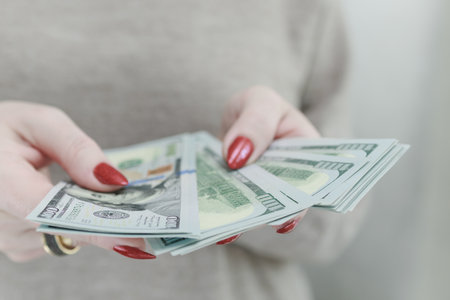 woman's hands holding American dollar paper billsの写真素材